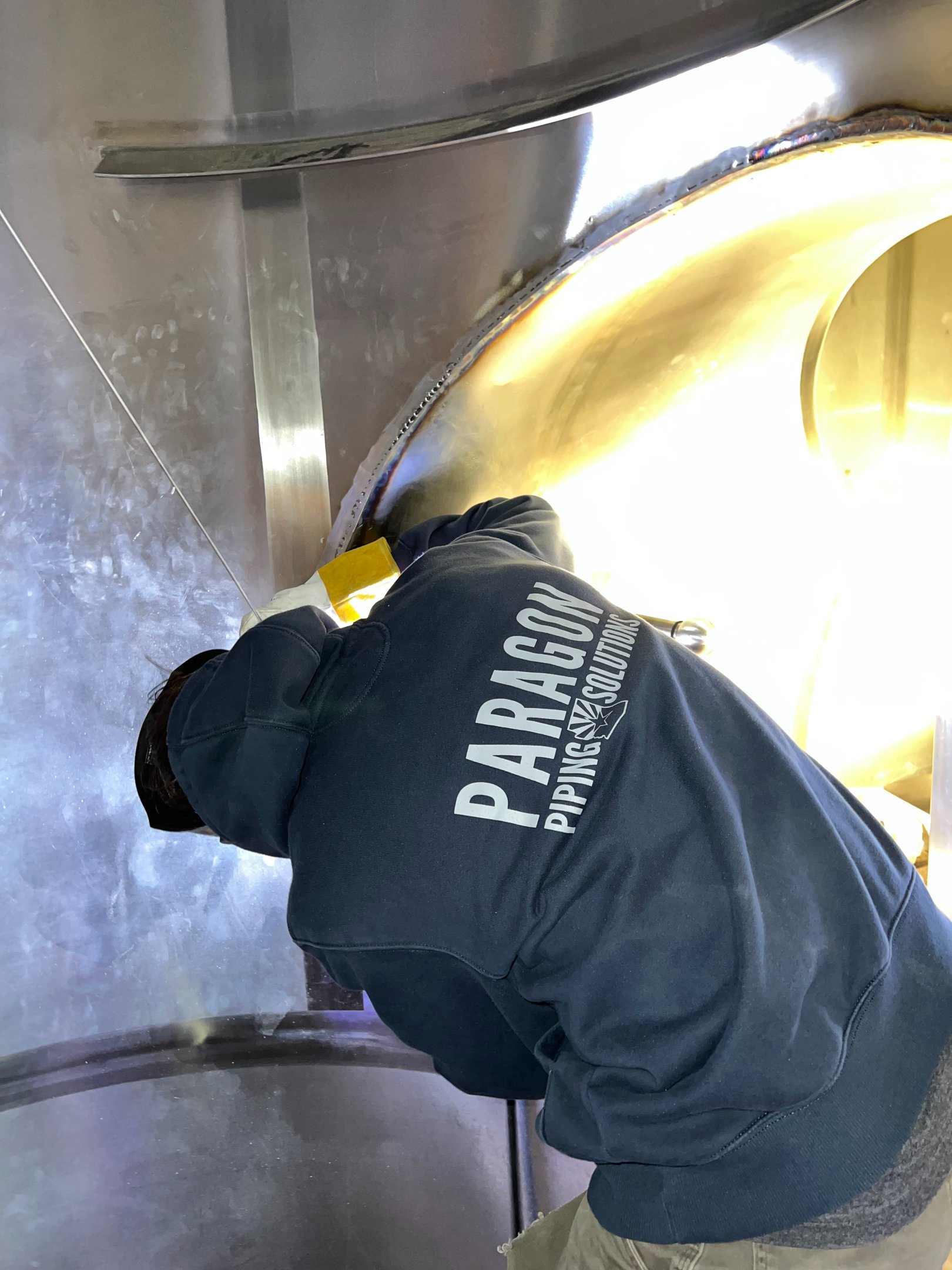 Paragon Piping technician welding inside stainless process equipment